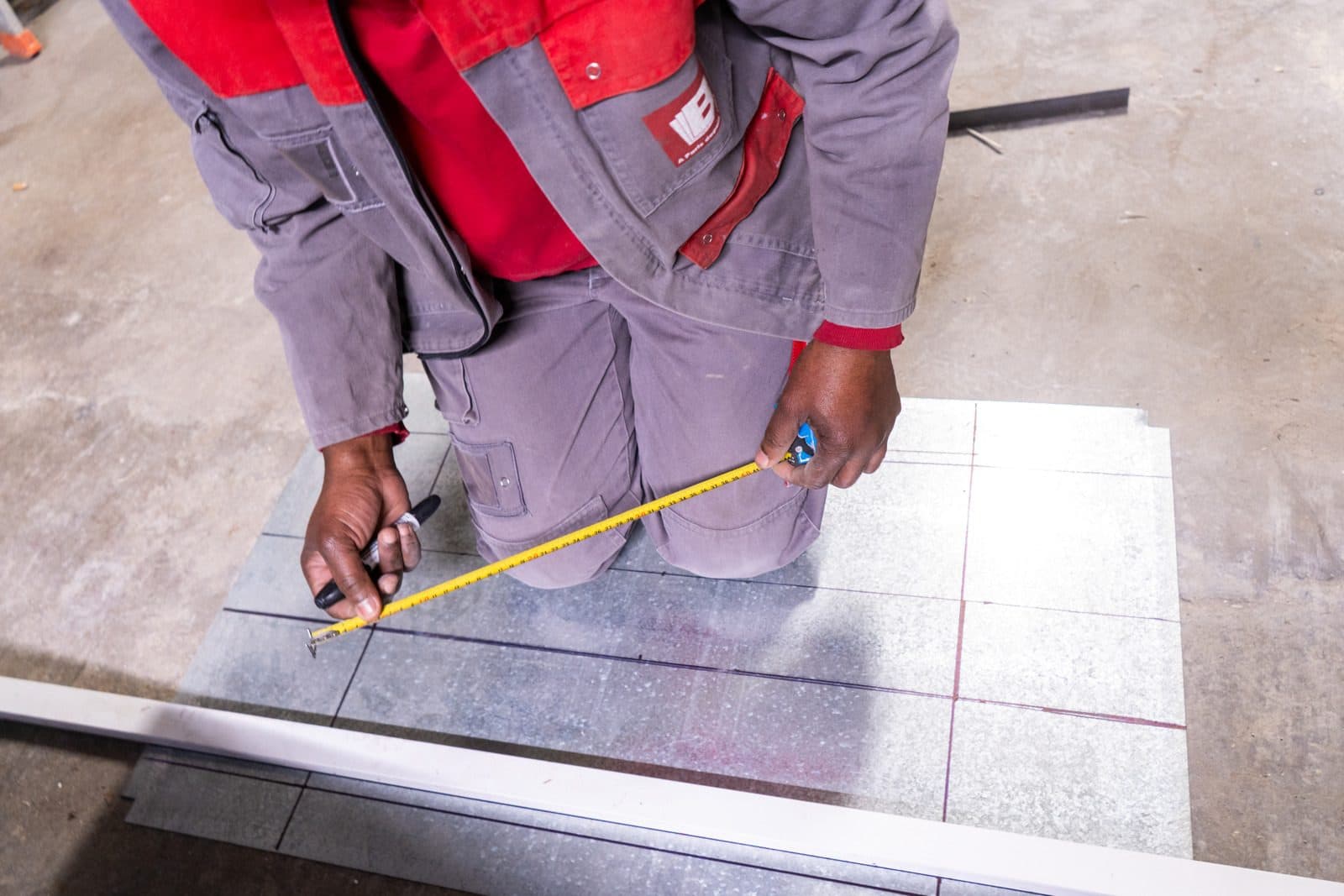 Couvreur-zingueur Bonnet Bafal mesurant une feuille de zinc en atelier